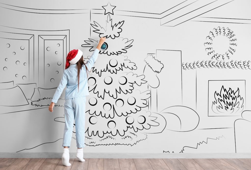 Une jeune fille joue avec un dessin peint sur un mur à l'aide d'un vidéoprojecteur